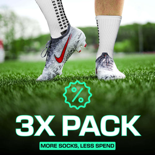 Multipack of white LUX grip socks football with anti-slip technology worn with cleats on grass field