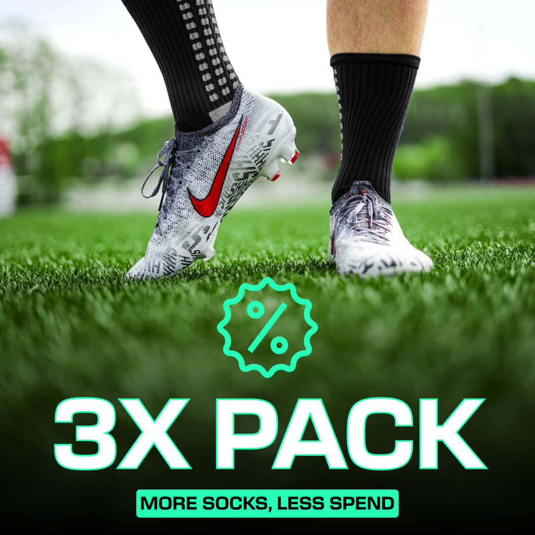 Black LUX grip socks football with anti-slip technology worn with cleats on grass field, 3-pack promotion text