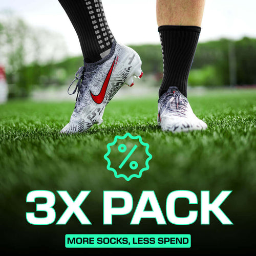 Black LUX grip socks football with anti-slip technology worn with cleats on grass field, 3-pack promotion text