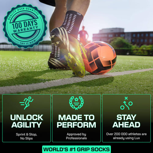 Black LUX anti-slip grip socks football multipack with grip array technology on grass field next to orange soccer ball